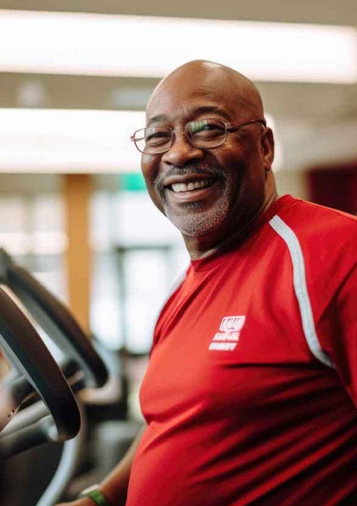 Smiling man at a treadmill console