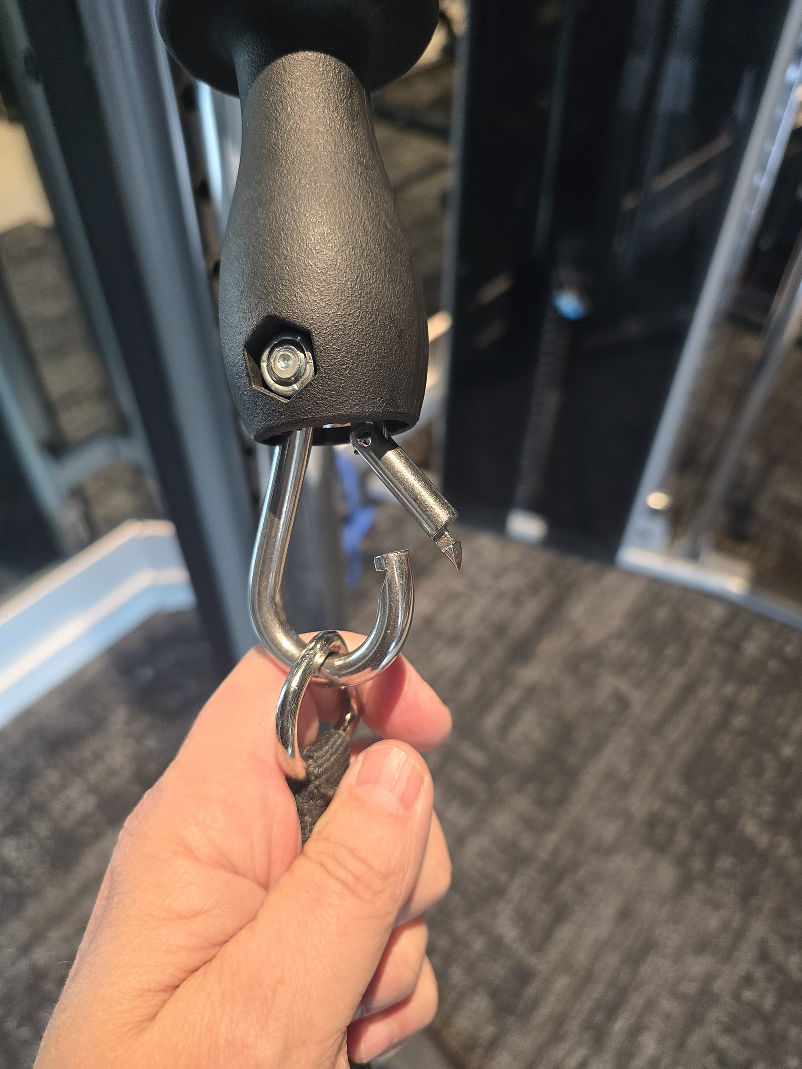 Replacement cable snap hook held up on a functional trainer